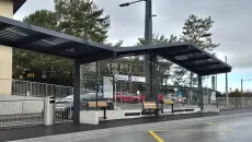 Horizontales Foto der Bushaltestelle „Place Centrale“ in Crissier mit transparentem Photovoltaikdach